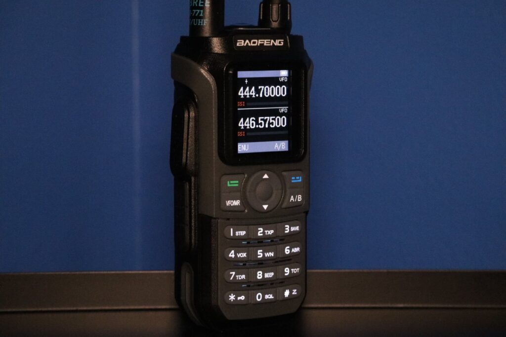Baofeng UV-21R handheld ham radio with dual frequency VFOs shown on screen.